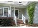 Charming home featuring a brick staircase leading to the front door, complemented by lush landscaping and a hanging flower basket at 104 Silver Fox Ct, Cary, NC 27511