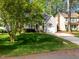Well-manicured front lawn and driveway feature home's facade, garage, and lush shade trees at 104 Silver Fox Ct, Cary, NC 27511