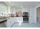Bright kitchen featuring white cabinets, stainless steel appliances, granite countertops, and marble-look flooring at 104 Silver Fox Ct, Cary, NC 27511
