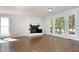 Spacious living room with hardwood floors, fireplace, and large windows offering natural light and outdoor views at 104 Silver Fox Ct, Cary, NC 27511