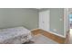 A bedroom features green walls, hardwood floors, a bed with a floral comforter, and two electrical outlets at 106 Kenneil Ct, Apex, NC 27502