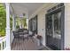 Inviting front porch featuring a cozy seating area with outdoor furniture and a black framed glass front door at 106 Kenneil Ct, Apex, NC 27502