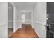 Bright hallway featuring hardwood floors, neutral paint, and doorway views into carpeted and dining areas at 1100 Brandywine Ln, Rocky Mount, NC 27804