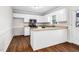 Bright kitchen featuring white cabinets, stainless steel appliances and wood flooring at 1100 Brandywine Ln, Rocky Mount, NC 27804