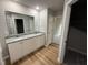 Bathroom featuring a double vanity with granite countertops, wood floors, and large mirror at 115 Oakfield Trace Dr, Four Oaks, NC 27524