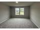 Spacious bedroom with plush carpet and two large windows offering ample natural light at 115 Oakfield Trace Dr, Four Oaks, NC 27524