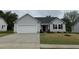 Charming single-story home with gray siding, a two-car garage, and a well-maintained lawn at 115 Oakfield Trace Dr, Four Oaks, NC 27524