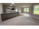 Open kitchen with gray cabinets, granite countertops, and stainless steel appliances at 115 Oakfield Trace Dr, Four Oaks, NC 27524