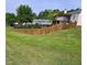 View of the spacious backyard with a wood fence, lush lawn, and a deck with a pergola at 1202 Lexington Ridge Ln, Apex, NC 27502