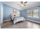 Comfortable bedroom featuring a large bed, two windows, ceiling fan, and blue accent walls at 1202 Lexington Ridge Ln, Apex, NC 27502