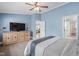 Spacious blue bedroom with a large TV, hardwood floors, and access to other rooms at 1202 Lexington Ridge Ln, Apex, NC 27502