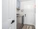 Well-lit laundry room with a modern washer and dryer, custom cabinet, and stylish decor at 1202 Lexington Ridge Ln, Apex, NC 27502