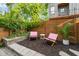 Cozy backyard space with a wooden fence, lush green trees, and comfortable lounge seating at 1202 S Bloodworth St, Raleigh, NC 27601