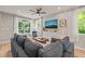 Inviting living room with a gray sofa, large windows, and wood floors at 1202 S Bloodworth St, Raleigh, NC 27601