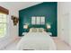 A serene bedroom with a teal accent wall, ambient lighting, and soft neutral bedding at 1311 Antler Point Dr, Durham, NC 27713