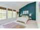 Stylish bedroom with a vaulted ceiling, a deep teal accent wall, and large sunny windows at 1311 Antler Point Dr, Durham, NC 27713