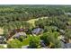Aerial view of a home located on a golf course surrounded by tall pine trees and manicured lawns at 1317 Colonial Club Rd, Wake Forest, NC 27587