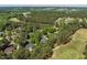 Aerial view of a home located on a golf course surrounded by tall pine trees and other homes at 1317 Colonial Club Rd, Wake Forest, NC 27587