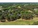 Aerial view showcasing the home in a wooded neighborhood near a golf course with tree coverage at 1317 Colonial Club Rd, Wake Forest, NC 27587