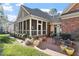 Brick patio featuring a screened in porch, lush landscaping and outdoor seating area at 1317 Colonial Club Rd, Wake Forest, NC 27587