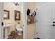 Well-lit half bathroom with a toilet and a sink next to a white door with multiple hats hanging at 1317 Colonial Club Rd, Wake Forest, NC 27587