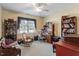 Comfortable bedroom featuring a ceiling fan, rocking chair, large window, and a built-in desk area at 1317 Colonial Club Rd, Wake Forest, NC 27587