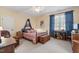 Inviting bedroom with a cozy bed, large window with blue curtains, and ample natural light at 1317 Colonial Club Rd, Wake Forest, NC 27587