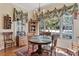 Bright dining room with large windows, custom draperies, and a decorative chandelier and table with seating at 1317 Colonial Club Rd, Wake Forest, NC 27587