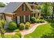 Two-story brick home with black shutters, covered porch, manicured landscaping, and brick walkway at 1317 Colonial Club Rd, Wake Forest, NC 27587