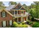 Beautiful two-story brick home with a covered porch, white columns, black shutters, and lush green landscaping at 1317 Colonial Club Rd, Wake Forest, NC 27587