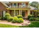 Charming brick home featuring manicured landscaping, a covered porch with columns, and a second-story balcony at 1317 Colonial Club Rd, Wake Forest, NC 27587