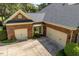 Attached two-car garage with a concrete driveway, with established landscape beds and a covered entrance at 1317 Colonial Club Rd, Wake Forest, NC 27587