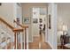 Hallway view with hardwood floors, white trim, and natural light, leading to other rooms in the house at 1317 Colonial Club Rd, Wake Forest, NC 27587