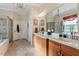 Main bathroom featuring dual sinks, a large mirror, soaking tub and glass enclosed shower at 1317 Colonial Club Rd, Wake Forest, NC 27587