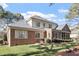 Rear exterior of a brick home featuring an enclosed porch and a spacious backyard at 1317 Colonial Club Rd, Wake Forest, NC 27587