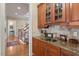 Wet bar featuring granite countertops, custom cabinets, and a stylish sink with backsplash at 1317 Colonial Club Rd, Wake Forest, NC 27587