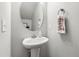 Neutral-toned powder room with pedestal sink, stylish fixtures, and a decorative mirror at 1322 Regulator St, Raleigh, NC 27603