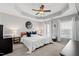Spacious bedroom with a tray ceiling, ceiling fan, and large windows for natural light at 1322 Regulator St, Raleigh, NC 27603
