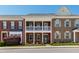 Charming two-story brick townhome featuring double balconies and a well-manicured lawn and flowering bushes at 1322 Regulator St, Raleigh, NC 27603