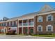 Charming townhome showcasing brick facade, covered porch and balcony, and landscaped front yard at 1322 Regulator St, Raleigh, NC 27603