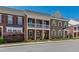 Charming townhome showcasing brick facade, covered porch and balcony, and landscaped front yard at 1322 Regulator St, Raleigh, NC 27603