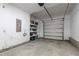 A well-lit garage with white walls, concrete floor, shelves, and a roll-up door at 1322 Regulator St, Raleigh, NC 27603