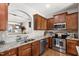 Well-lit kitchen boasts stainless steel appliances, granite countertops, and stylish wood cabinetry at 1322 Regulator St, Raleigh, NC 27603