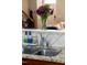 Close-up of kitchen sink with granite countertop and backsplash, next to stainless appliances at 1322 Regulator St, Raleigh, NC 27603