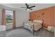 Bedroom with an orange accent wall, ceiling fan, and view of the outdoors at 1410 Arena Ln, Fuquay Varina, NC 27526