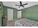Bedroom with green walls, ceiling fan, carpet, and ample closet space for storage at 1410 Arena Ln, Fuquay Varina, NC 27526