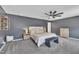 Bright bedroom with neutral gray walls, carpet, ceiling fan, and a padded headboard at 1410 Arena Ln, Fuquay Varina, NC 27526