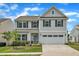 Charming two-story home featuring a two-car garage, well-manicured lawn, and inviting front porch at 1410 Arena Ln, Fuquay Varina, NC 27526