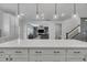 Bright kitchen with white cabinets, quartz counters, stainless appliances and open concept view to living room at 1410 Arena Ln, Fuquay Varina, NC 27526