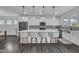 Modern kitchen with white cabinets, a large kitchen island with seating, and stainless steel appliances at 1410 Arena Ln, Fuquay Varina, NC 27526